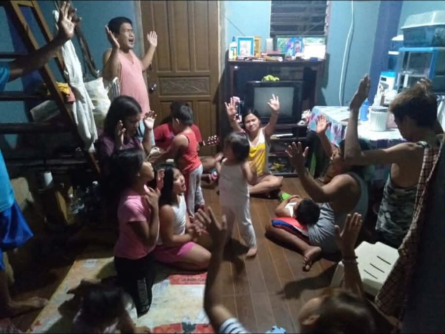 The congregation gathered for nightly prayer devotion, hands raised in worship